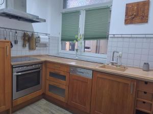 a kitchen with wooden cabinets and a sink and a window at Gemütliche 4-Zimmer Wohnung mit 7 Schlafplätzen in Chemnitz
