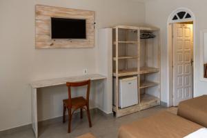 a room with a desk and a tv on a wall at Pousada Jangadeiro in Porto Seguro +37 photos