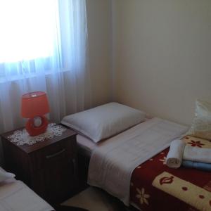 a bedroom with two beds and a lamp on a night stand at Holiday home Boba in Rakovica