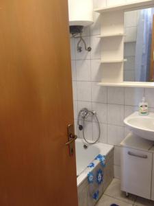 a bathroom with a door with a sink and a shower at Holiday home Boba in Rakovica