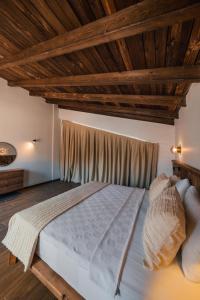 a large bed in a room with wooden ceilings at Cevizdibi Hotel in Masukiye