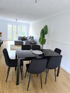 a dining room with a black table and chairs at Stunning 3Bed 2bath family home with Garden in London