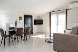 a living room with a table and chairs and a couch at HOME WITH VIEW in Xanthi