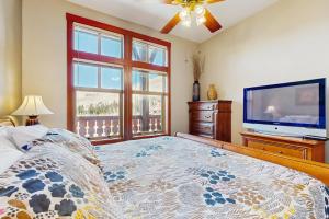 a bedroom with a bed and a flat screen tv at Eagle Springs East 402: Buffaloberry Suite in Solitude