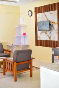 a living room with a chair and a tv at Mylon deluxe in Nakuru