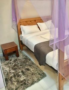 a bedroom with a bed and a nightstand and a bed sidx sidx at Mylon deluxe in Nakuru
