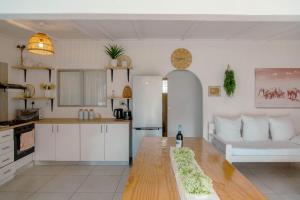 a kitchen and living room with a refrigerator and a table at The Ocean Side Cottage in Cape Town