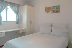 a white bedroom with a white bed and a window at The Ocean Side Cottage in Cape Town +13 photos