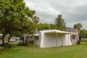 a small white house in a yard at The Ocean Side Cottage in Cape Town