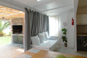 a living room with a couch in front of a window at The Ocean Side Cottage in Cape Town