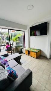 a living room with a couch and a tv at Baku Laureles Hostel in Medellín