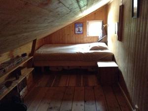 um quarto com uma cama num quarto de madeira em Lusthuset em Sölvesborg
