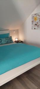a bedroom with a large bed with a blue blanket at auszeit34 in Ebelsbach