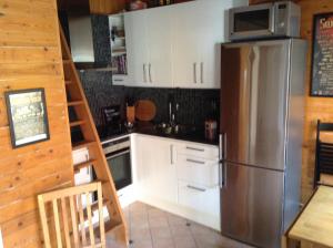 uma cozinha com armários brancos e um frigorífico de aço inoxidável em Lusthuset em Sölvesborg