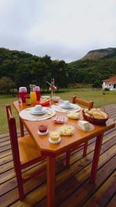 a wooden table with food on it on a deck at Refúgio na Serra dos Garcias in Aiuruoca