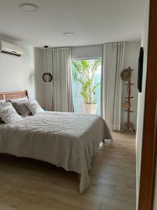 a bedroom with a bed and a large window at Buzios casa Geriba in Búzios
