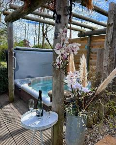 a hot tub with a table and two glasses of wine at "ZeeLandZon" Holiday home by the lake with Jacuzzi and Sauna in Herkingen