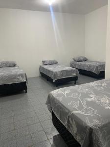 a room with three beds in a room at RS Pousada in Bayeux