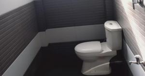 Un baño con un inodoro blanco y una pared negra. en S And K Holiday Stay, en Beruwala