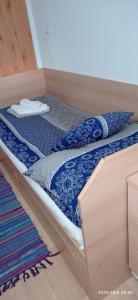a bed with a blue and white comforter on it at Magyar Tenger Pihenőház, house for 8 with garden at Balaton in Balatonkenese