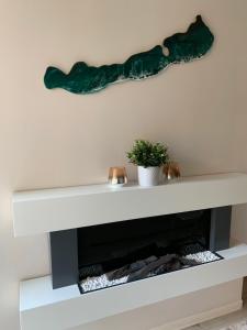 Una chimenea con una escultura de vidrio verde encima. en Relax Apartman Siófok, en Siófok