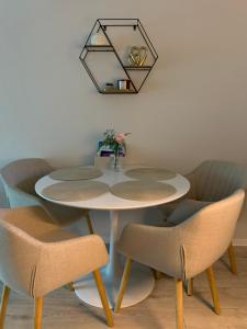 una mesa blanca con sillas y un espejo en la pared en Relax Apartman Siófok, en Siófok