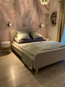 Un dormitorio con una cama con una pared con plumas. en Relax Apartman Siófok, en Siófok 26 fotos más