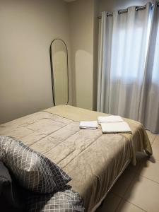 a bed with two towels on it with a mirror at VIVA - Centro - Garagem - Apt 1 Dormitório in Santa Maria