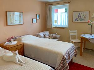 una camera da letto con due letti e un gatto sdraiato sui letti di FeWo im Dreiländereck a Büchlberg