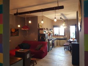Una sala de estar con un sofá rojo y una cocina. en Ai 4 gatti, en Mascalucia