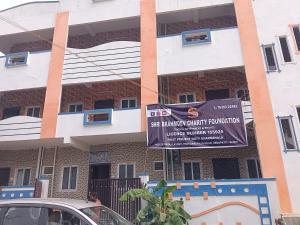 un bâtiment avec une enseigne devant lui dans l'établissement Sona rooms, à Coimbatore