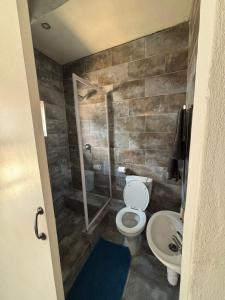 Un baño con inodoro, ducha y lavabo. en Glowti Event & Guest House, en Centurion