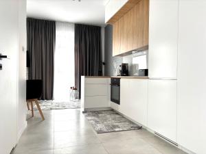 Una cocina con gabinetes blancos y una estufa. en EASY RENT- Business Center 194 Free Parking 24h Check-in, en Lublin