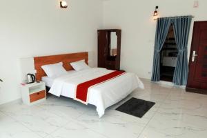a bedroom with a large bed with a red and white blanket at Dreams Holidays Vagamon in Vagamon