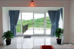 a room with a sliding glass door with a balcony at Dreams Holidays Vagamon in Vagamon