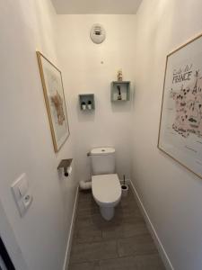 Un baño con inodoro y un cuadro en la pared. en Appartement terrasse entre Paris et Disney, en Bry-sur-Marne 25 fotos más