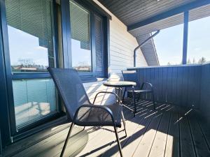 a porch with chairs and a table and windows at good mood guesthouse in Otepää