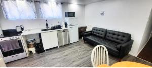 a living room with a black couch and a kitchen at Cute & Spacious 2 BDR condo in Montréal +25 photos