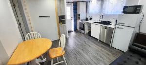 a kitchen with a wooden table and a kitchen with a refrigerator at Cute 2 BDR condo in Montreal