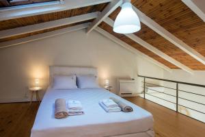 une chambre avec un grand lit avec des serviettes dessus dans l'établissement Krouzeri Beach Apartments, à Nisakion