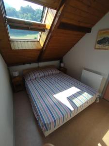 a bedroom with a bed with a large window at Alt'à Luz, Duplex 2 étoiles, 4 Pers , Ménage inclus in Luz-Saint-Sauveur