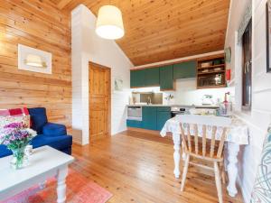 a kitchen and living room with green cabinets and a blue couch at 1 Bed in Clovelly 00354 in Clovelly