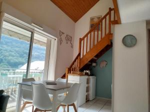 a dining room with a table and chairs and a staircase at Alt'à Luz, Duplex 2 étoiles, 4 Pers , Ménage inclus in Luz-Saint-Sauveur