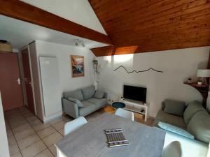 a living room with a couch and a table at Alt'à Luz, Duplex 2 étoiles, 4 Pers , Ménage inclus in Luz-Saint-Sauveur