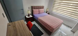 a small bedroom with a bed and a table at Apartamento Turistico Torre del molino in Bogotá