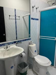 a bathroom with a white toilet and a sink at Hotel Rodasuites in Santa Marta +44 photos
