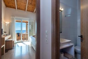 La salle de bains est pourvue de toilettes et d'un lavabo avec vue sur l'océan. dans l'établissement Krouzeri Beach Apartments, à Nisakion 162 autres photos