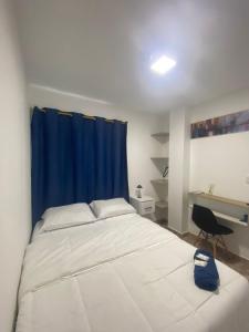 a bedroom with a bed with a blue curtain and a desk at Hotel Boutique DL in Cartagena de Indias