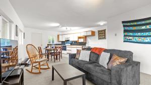 a living room with a couch and a table at Incredible Water Views Deck Relaxing Retreat Greenbank Getaway by AvantStay in Greenbank
