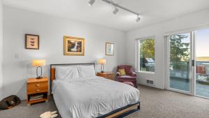 a bedroom with a bed and a chair and a window at Incredible Water Views Deck Relaxing Retreat Greenbank Getaway by AvantStay in Greenbank